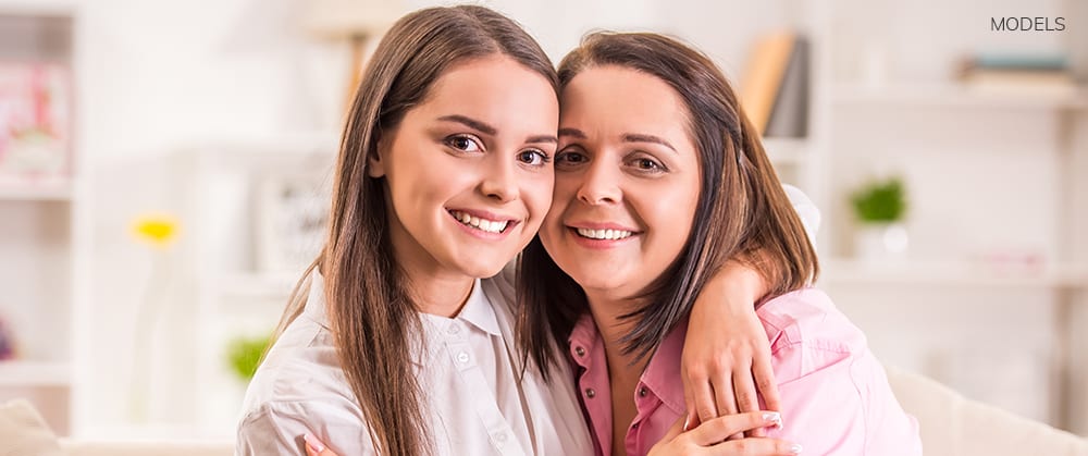 Mother and Daughter Embracing and Smiling With Pink Shirts